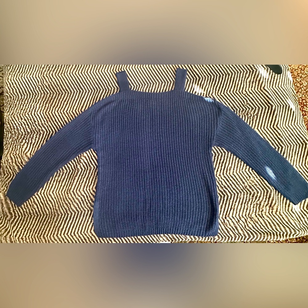 Blue sweater with straps and cut out shoulders.